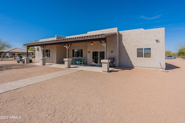 rear view of house featuring a patio area, a tiled roof, a ceiling fan, and stucco siding