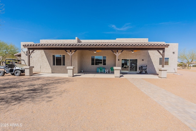 back of property with a patio, a ceiling fan, and stucco siding