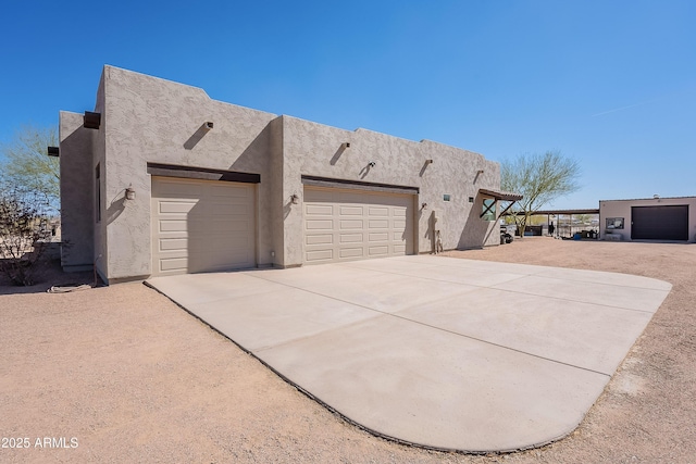 view of home's exterior with a garage, concrete driveway, and stucco siding