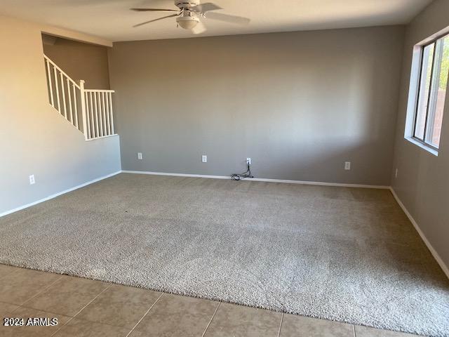 carpeted empty room featuring ceiling fan