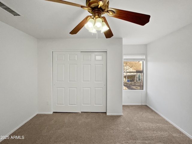 unfurnished bedroom featuring light colored carpet, ceiling fan, and a closet