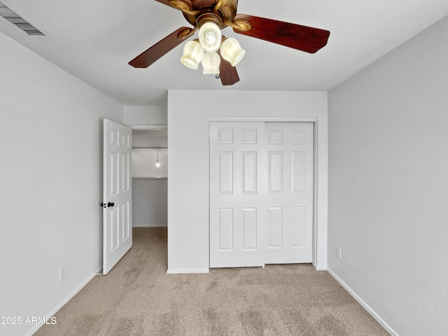 unfurnished bedroom with light colored carpet, ceiling fan, and a closet