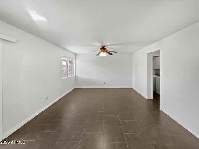 spare room with dark tile patterned floors and ceiling fan