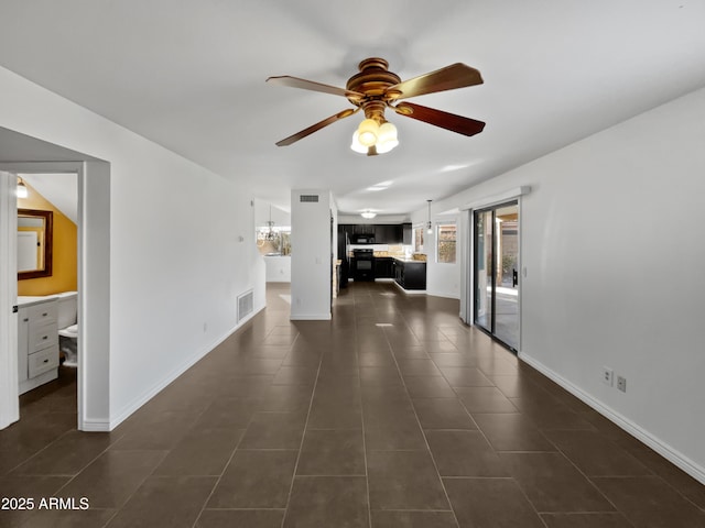 interior space featuring dark tile patterned flooring and ceiling fan with notable chandelier