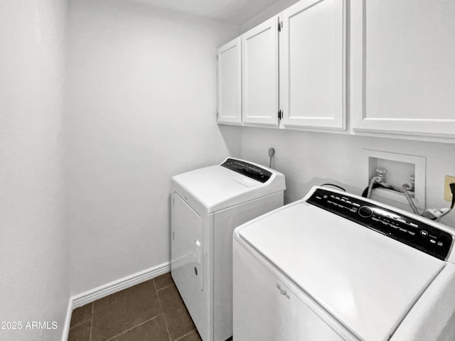 clothes washing area with cabinets, dark tile patterned floors, and washing machine and clothes dryer