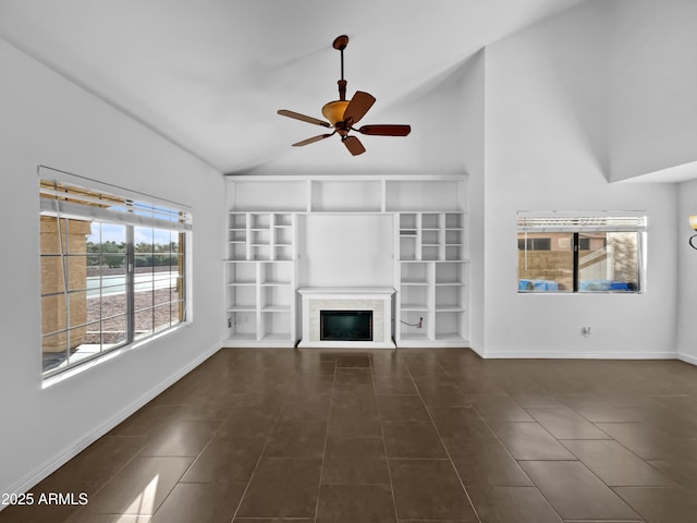 unfurnished living room featuring ceiling fan, lofted ceiling, and dark tile patterned flooring