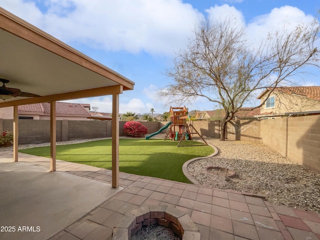 view of patio with a playground and a fire pit