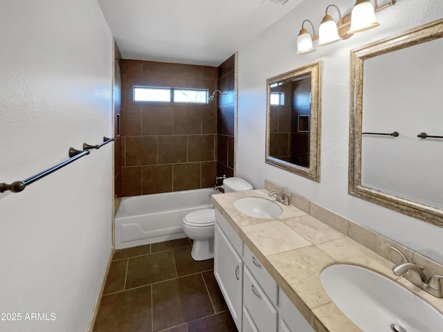 full bathroom with tiled shower / bath, vanity, tile patterned floors, and toilet