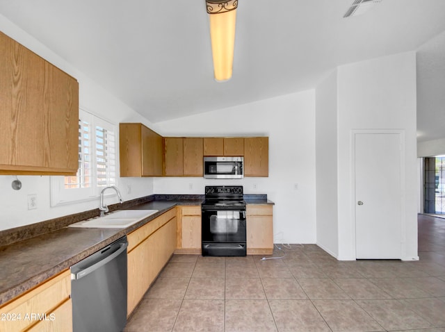 kitchen with light tile patterned flooring, lofted ceiling, stainless steel appliances, and sink