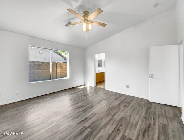 empty room featuring dark hardwood / wood-style floors, ceiling fan, and vaulted ceiling