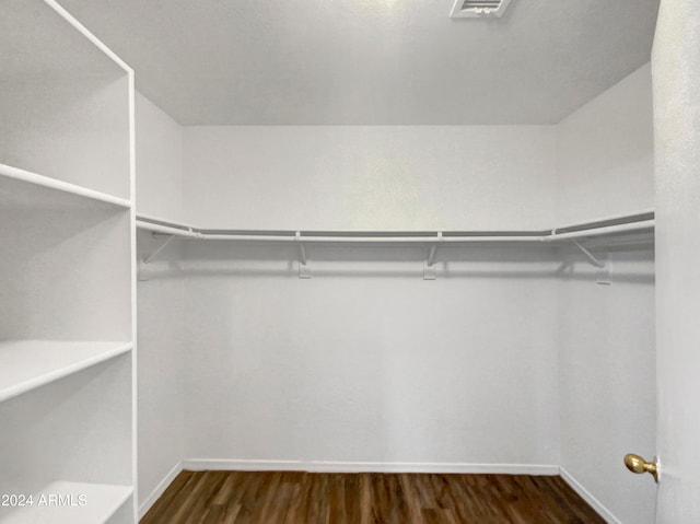 spacious closet with dark hardwood / wood-style floors