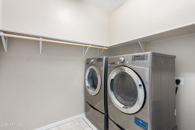 laundry area with light tile patterned flooring and washer and dryer