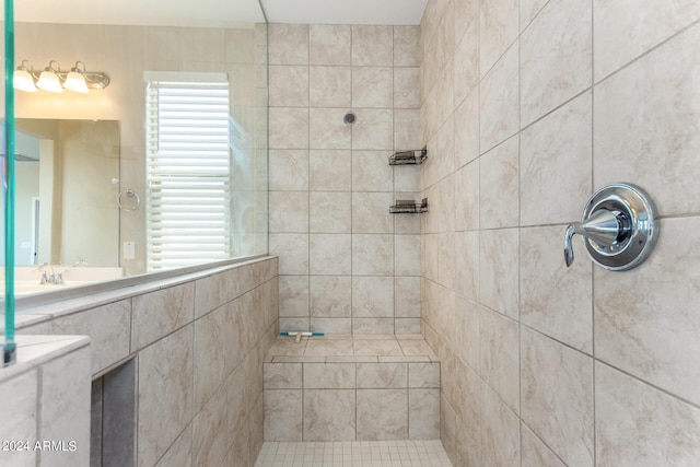 bathroom with vanity, tiled shower, and tile walls