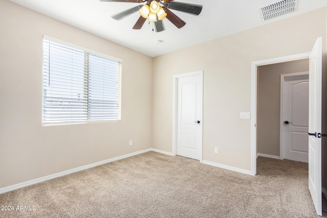 unfurnished bedroom featuring ceiling fan and light colored carpet