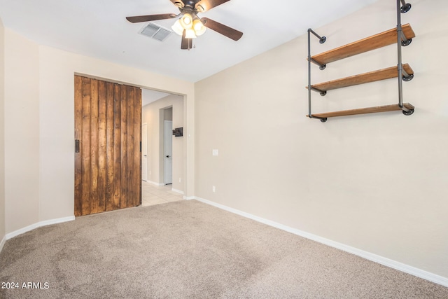 carpeted spare room featuring ceiling fan