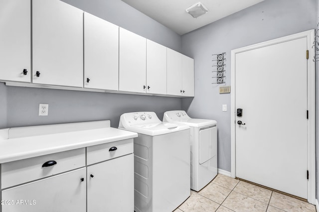 laundry room featuring light tile patterned floors, washing machine and dryer, and cabinets