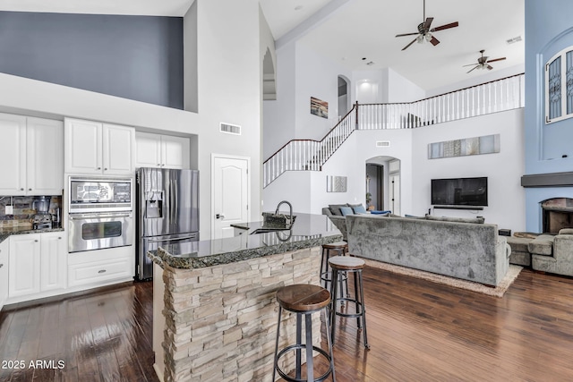 kitchen featuring white cabinetry, appliances with stainless steel finishes, sink, and a breakfast bar area