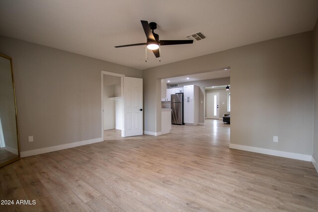 spare room with light wood-type flooring and ceiling fan