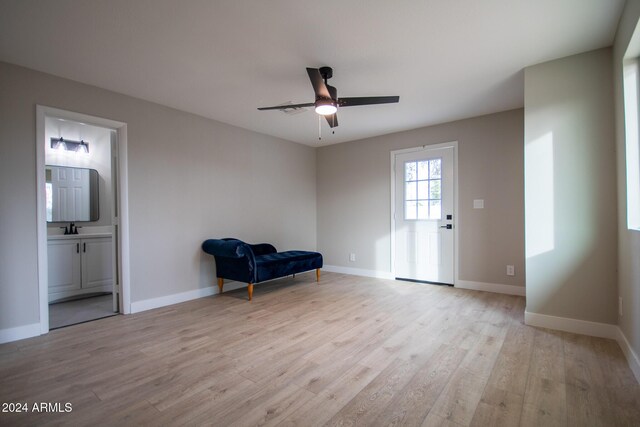 sitting room featuring ceiling fan, sink, and light wood-type flooring