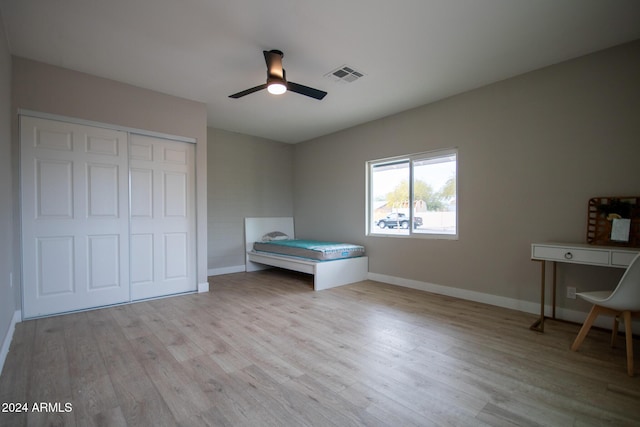 unfurnished bedroom with a closet, light hardwood / wood-style flooring, and ceiling fan