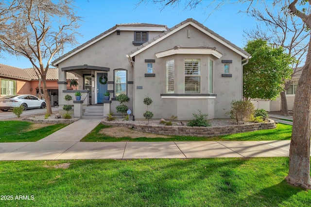 view of front facade featuring a tile roof, a front yard, fence, and stucco siding