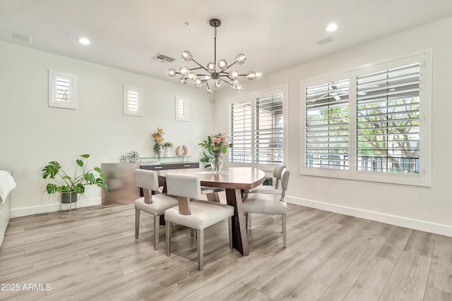 dining room featuring a notable chandelier, baseboards, visible vents, and light wood-style floors