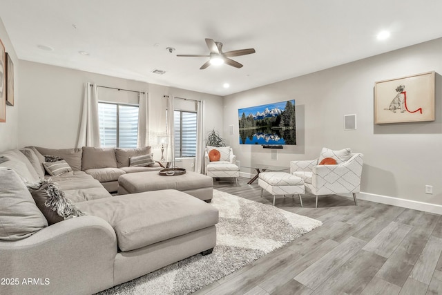 living area featuring light wood-type flooring, visible vents, and baseboards