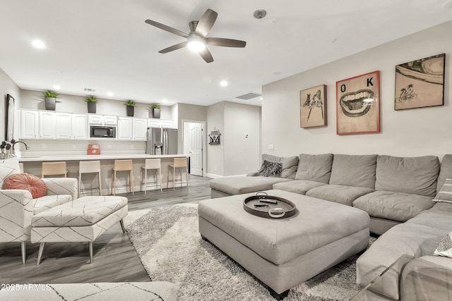 living area with ceiling fan, visible vents, wood finished floors, and recessed lighting