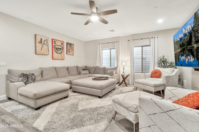 living area featuring a ceiling fan and visible vents