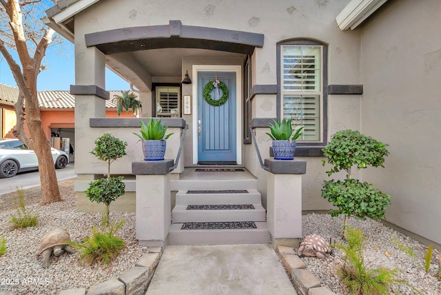 property entrance with concrete driveway and stucco siding