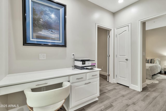 office space with light wood-type flooring and baseboards