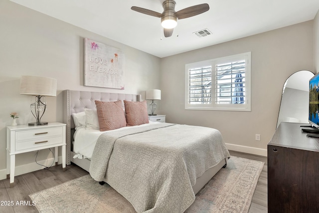 bedroom featuring a ceiling fan, light wood-type flooring, visible vents, and baseboards