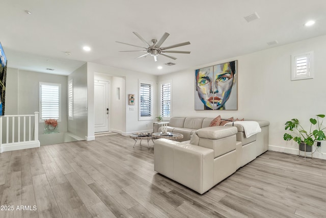 living room featuring light wood-style flooring, baseboards, and recessed lighting