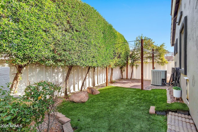 view of yard with central AC unit and a fenced backyard