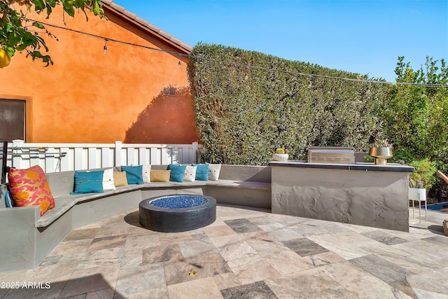 view of patio featuring a fire pit, area for grilling, and fence