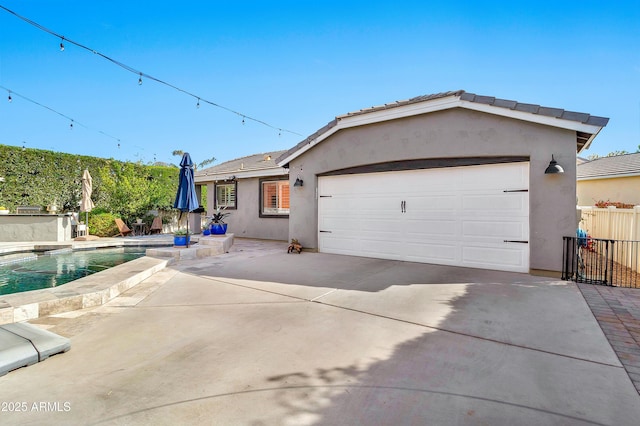 view of front facade featuring driveway, fence, a fenced in pool, and stucco siding