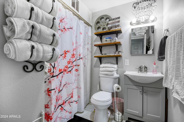 bathroom featuring a shower with shower curtain, toilet, vanity, and a chandelier