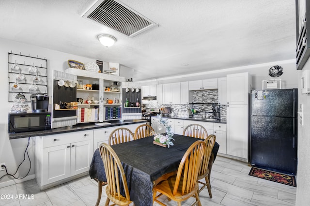 dining room featuring sink and a textured ceiling