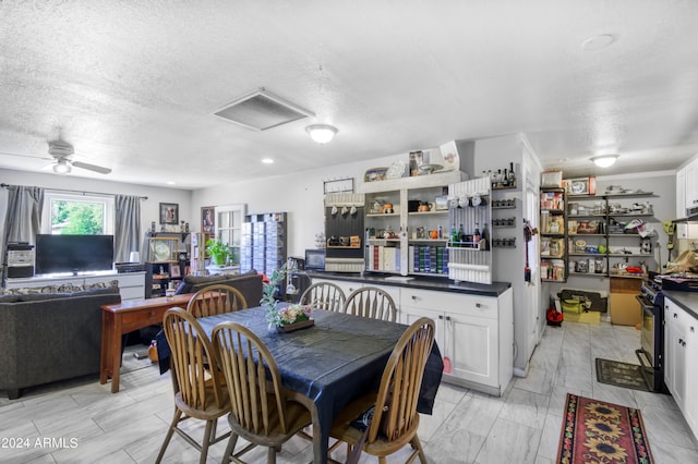 dining area with ceiling fan and a textured ceiling