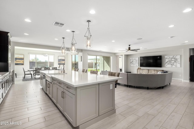 kitchen featuring light countertops, visible vents, a sink, and gray cabinetry