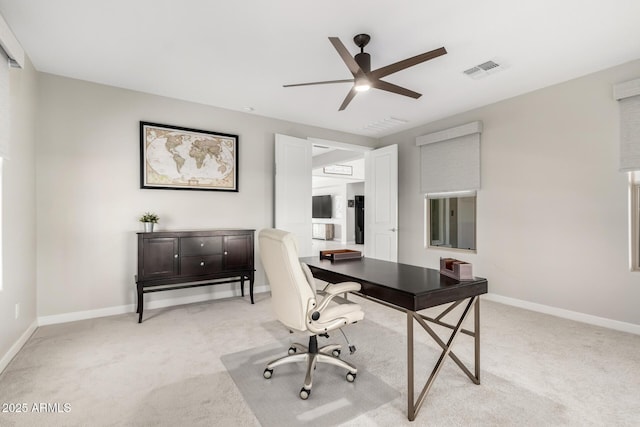 office space with light carpet, ceiling fan, visible vents, and baseboards