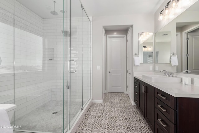 full bathroom with baseboards, a shower stall, vanity, and tile patterned floors