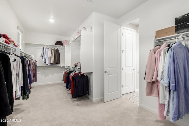 walk in closet with light colored carpet