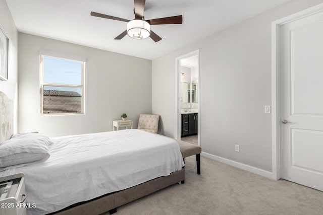 bedroom featuring light carpet, baseboards, a ceiling fan, and ensuite bathroom