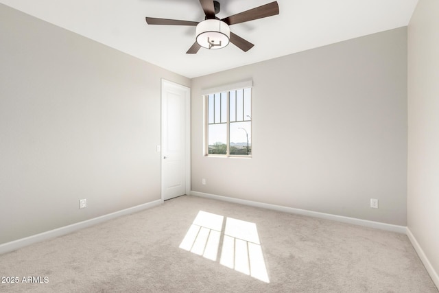 unfurnished room with carpet, a ceiling fan, and baseboards