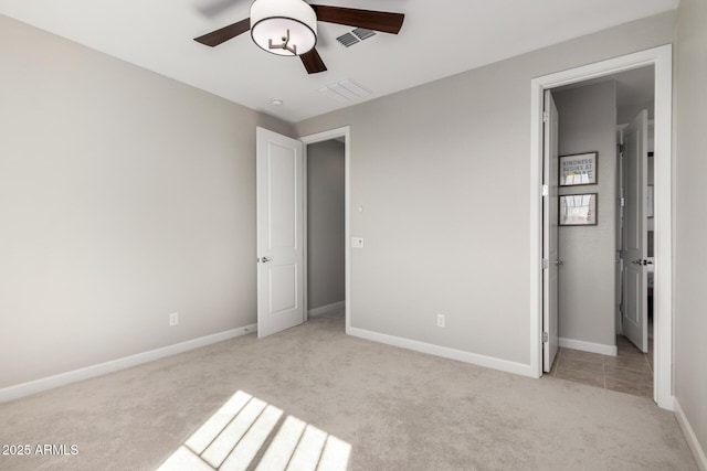 unfurnished bedroom with light colored carpet, ceiling fan, visible vents, and baseboards