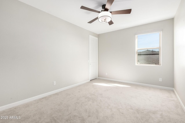 spare room featuring carpet, ceiling fan, and baseboards