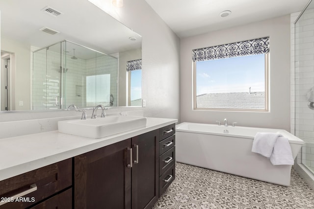 bathroom featuring a stall shower, visible vents, tile patterned flooring, vanity, and a freestanding tub