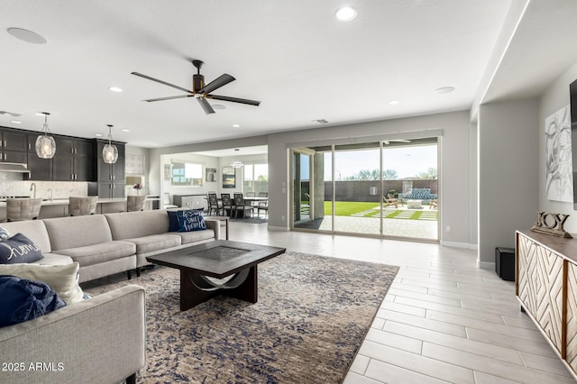 living room featuring recessed lighting, ceiling fan, and baseboards