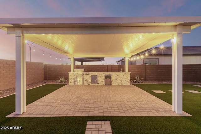 view of patio featuring a fenced backyard and an outdoor kitchen